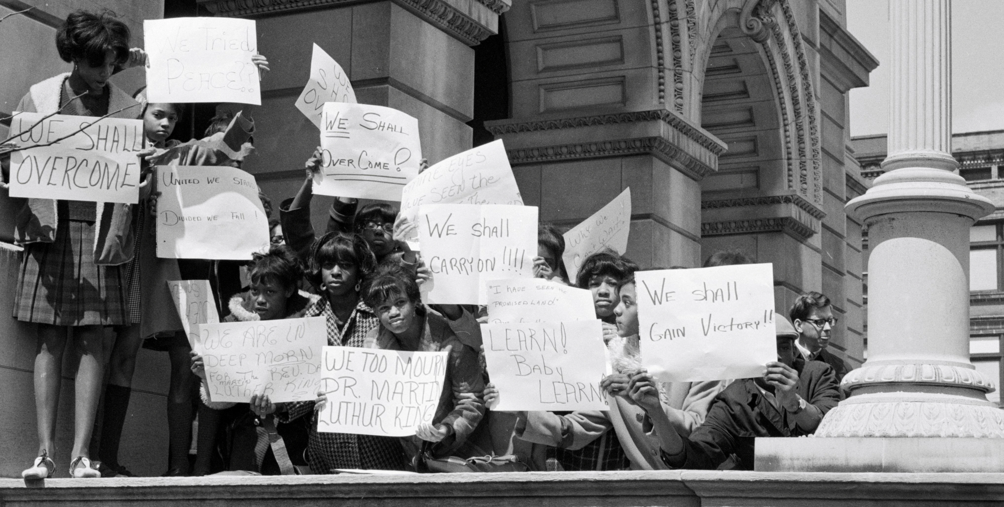 Unidentified women hold signs saying