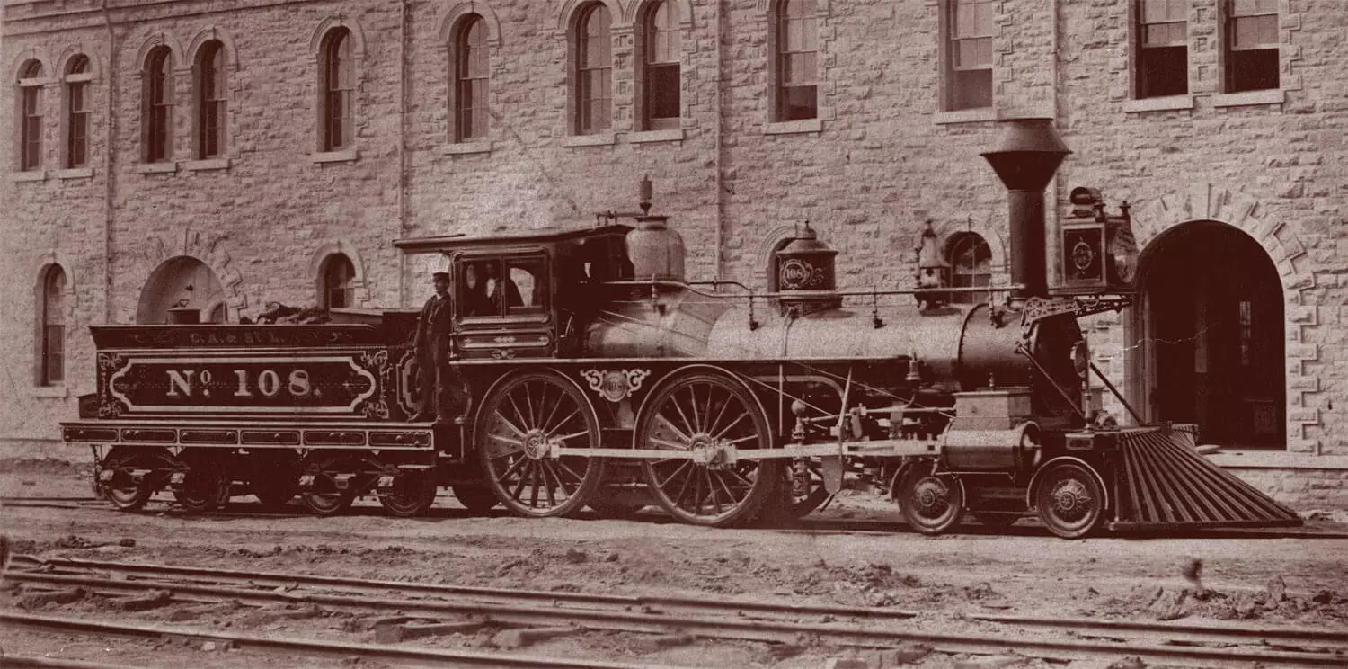 Photo of an engine parked outisde a large limestone building.