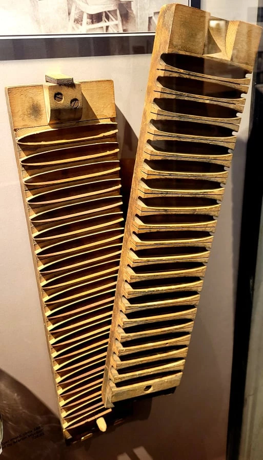 Two identical long wood rectangles with indentations for molding cigars. There are 20 indentations, and a small hole at the end. The two pieces fit together to make a complete mold.
