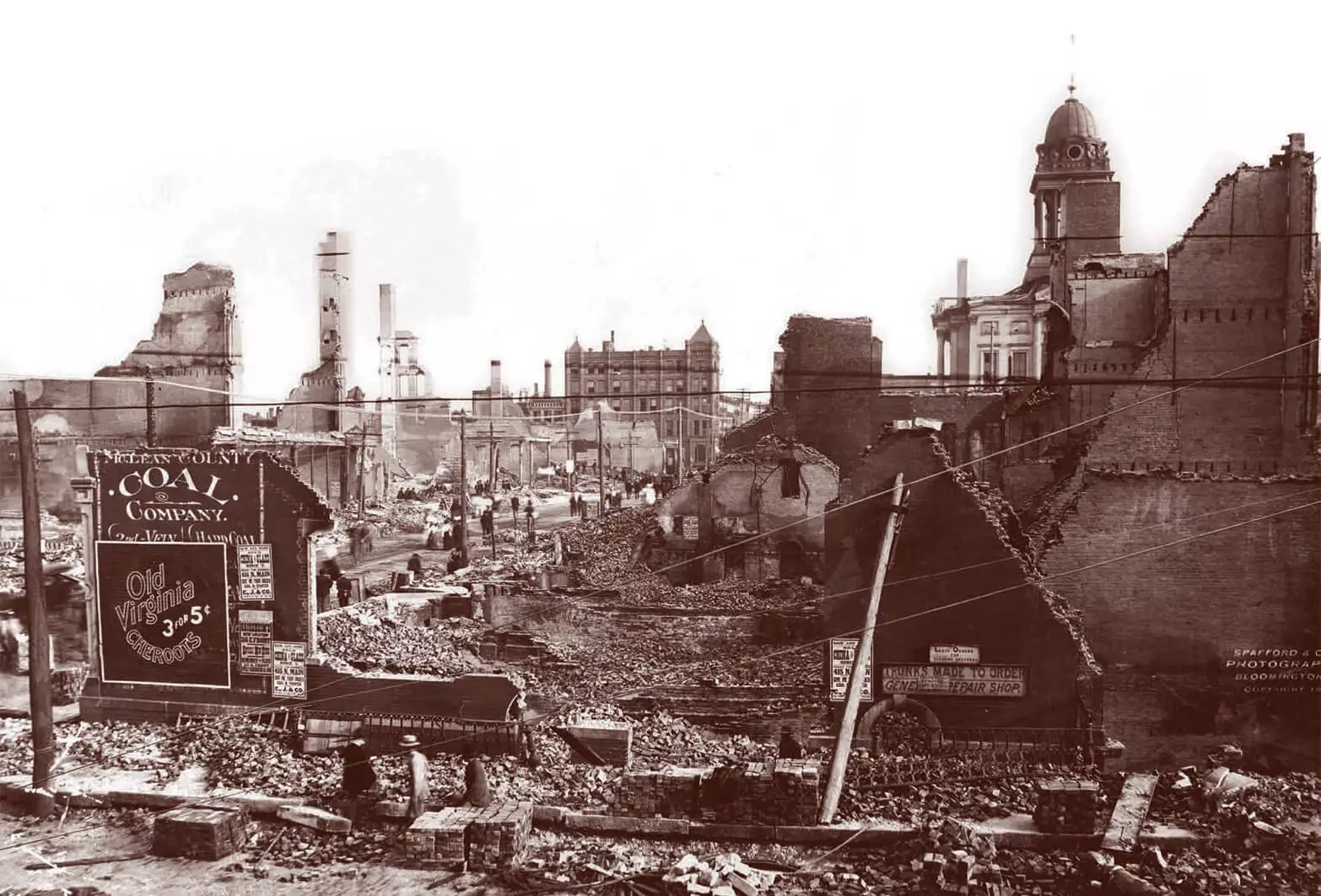Photo of rubble and destroyed buildings spanning multiple blocks. In the distance you can see the courthouse building and dome, which were destroyed but did not fall down.