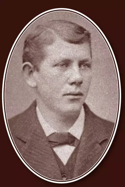 Portrait of a young man with wavy, side-parted hair, light colored eyes, and wearing a three-piece suit with bow tie.