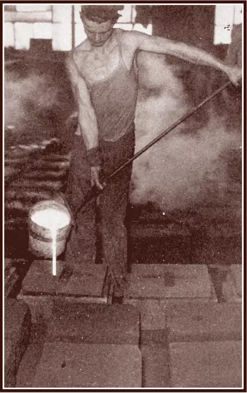 Light skinned man wearing a thin-strapped tank top holding a bucket with a long metal arm. Moulten metal is pouring out of the bucket. It looks like a very hot environment.