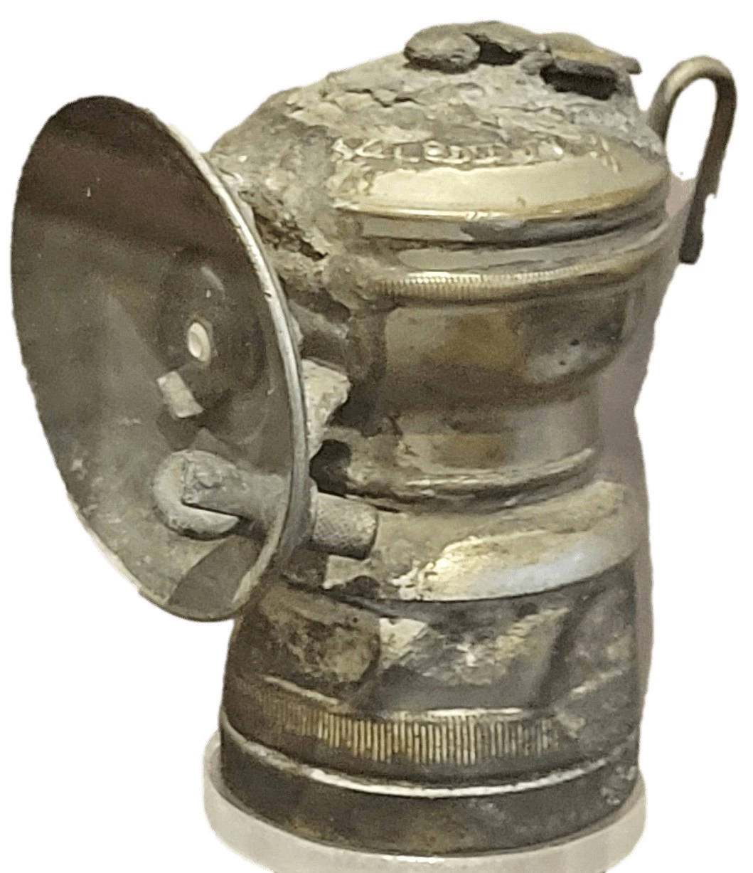 Cylindrical metal can with a disk on the left side and small hook on the right side.