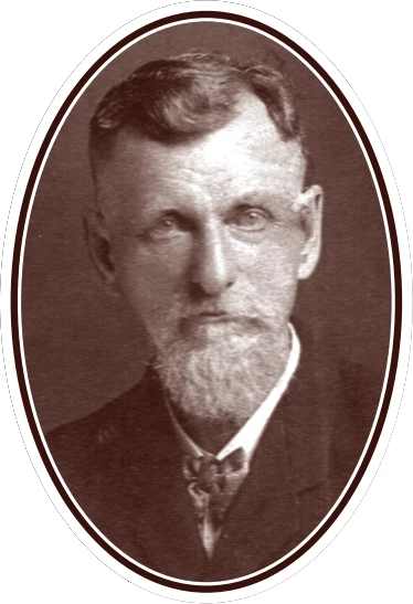 Photograph of an older white man with dark hair and a light beard and mustache