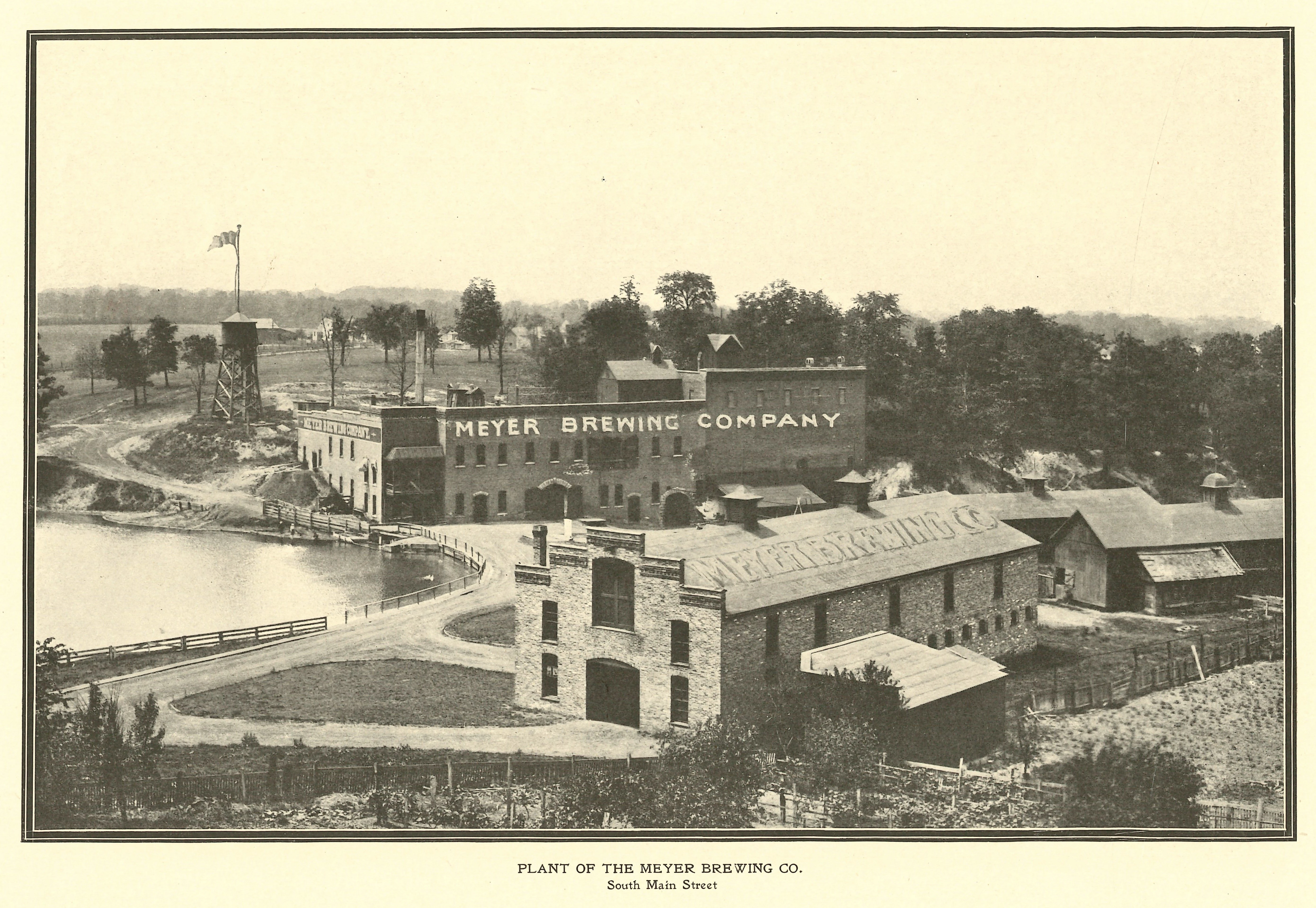 Two brick buildings labeled Meyer Brewing Company dominate a rolling hillside in south Bloomington, Illinois. The photo has a caption that reads