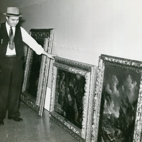Charles Stephenson Jr., a Central Illinois Art Exposition committee member, eyes several canvasses being readied for hanging.