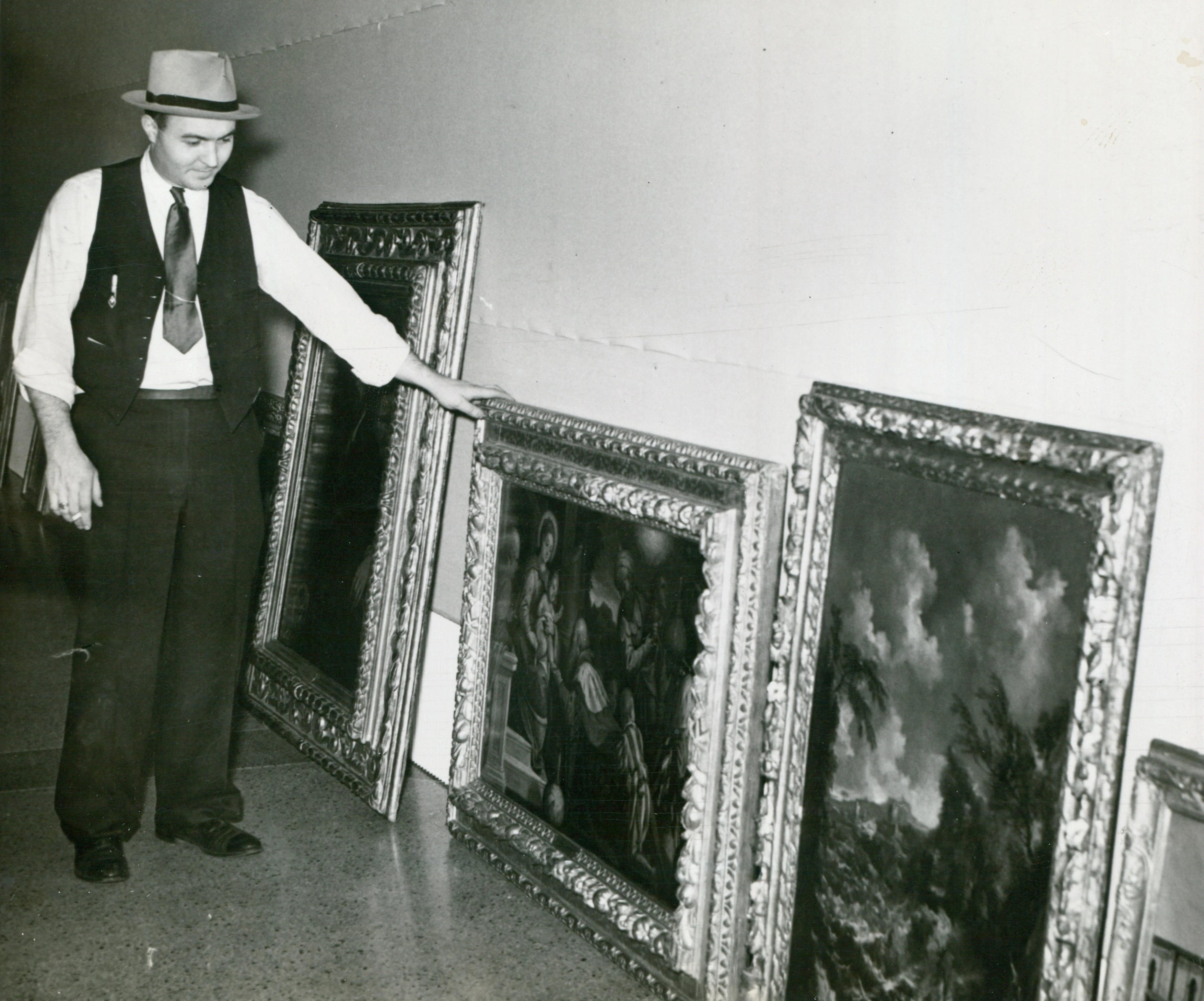 Charles Stephenson Jr., a Central Illinois Art Exposition committee member, eyes several canvasses being readied for hanging.