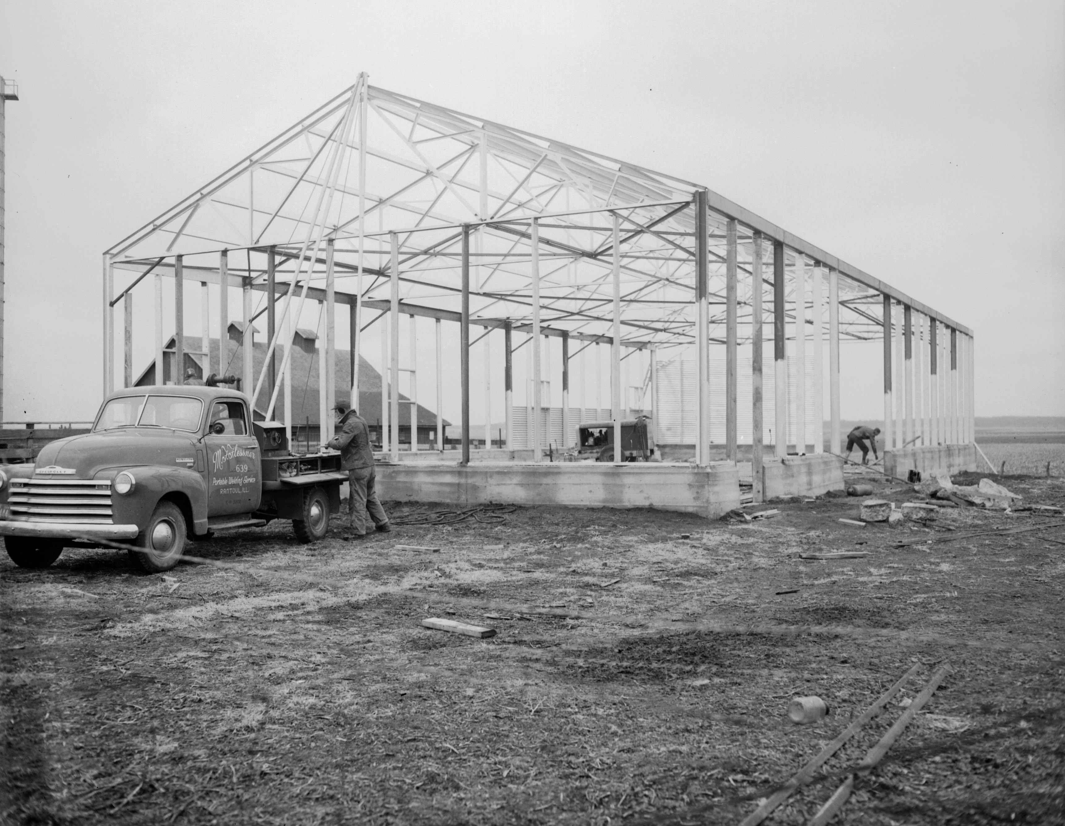 This all-steel “utility” farm building erected near LeRoy in November 1949 speaks to the transformation of Corn Belt barns in the post-World War II years, as the iconic wood-frame “big red barn” of rural Americana gave way to the utilitarian (and far less aesthetically pleasing) machine shed.