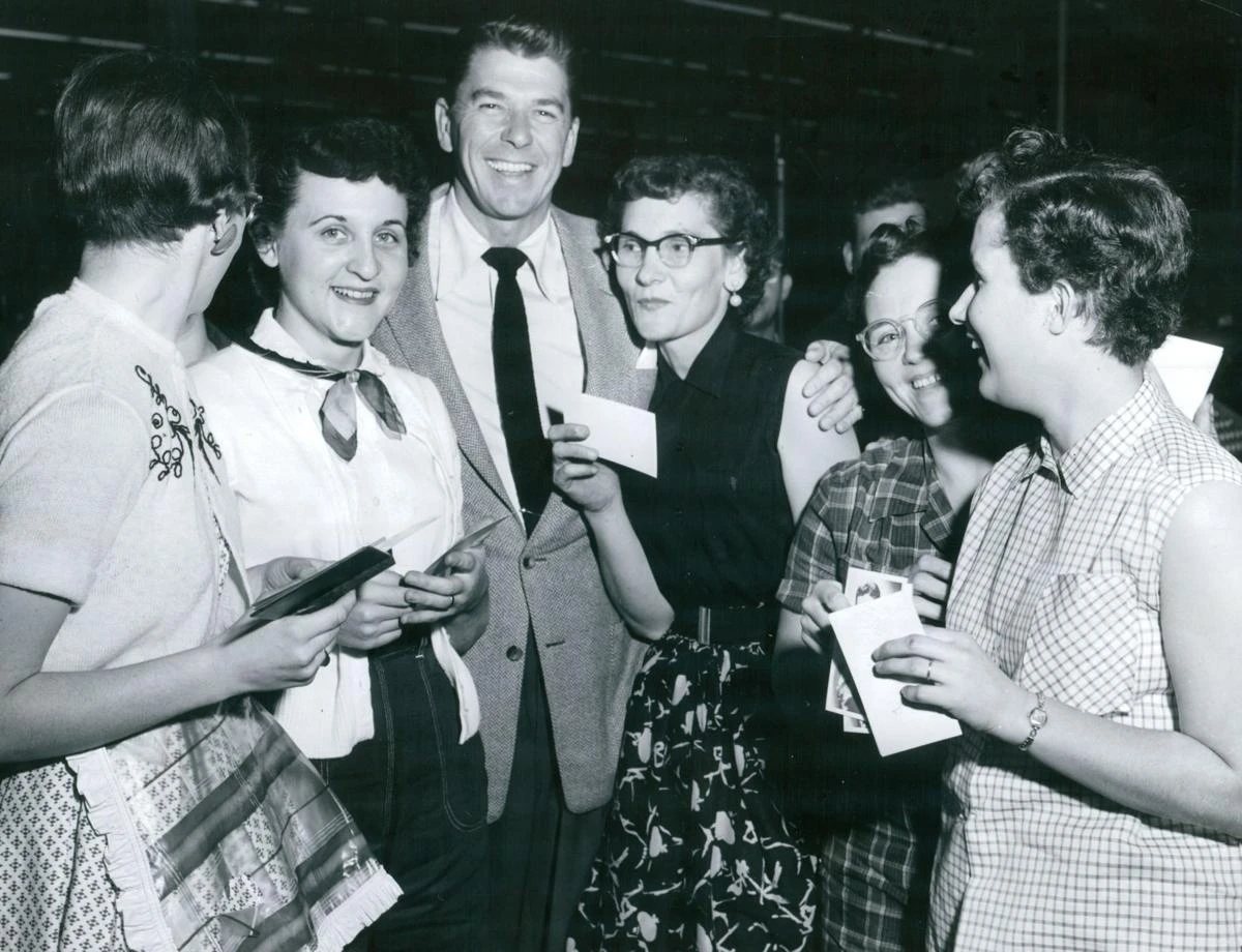 Regan stands in the middle of the photo surrounded by women