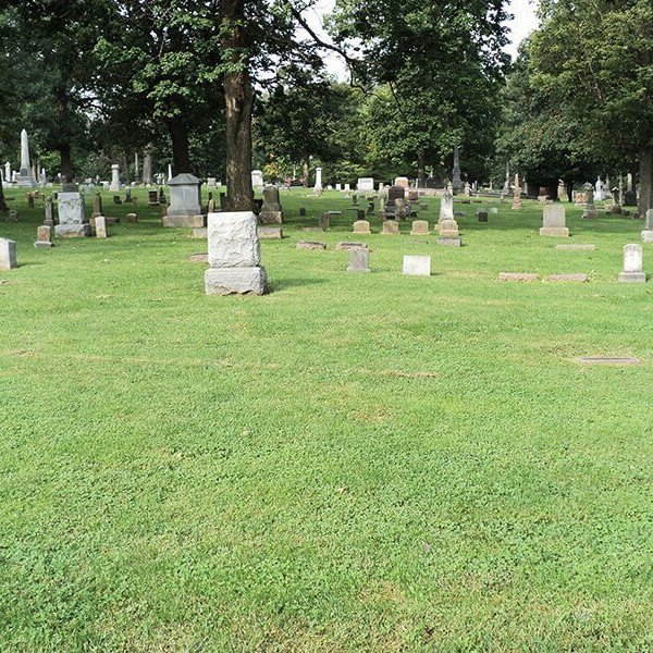 Headstones in a wooded cemetery