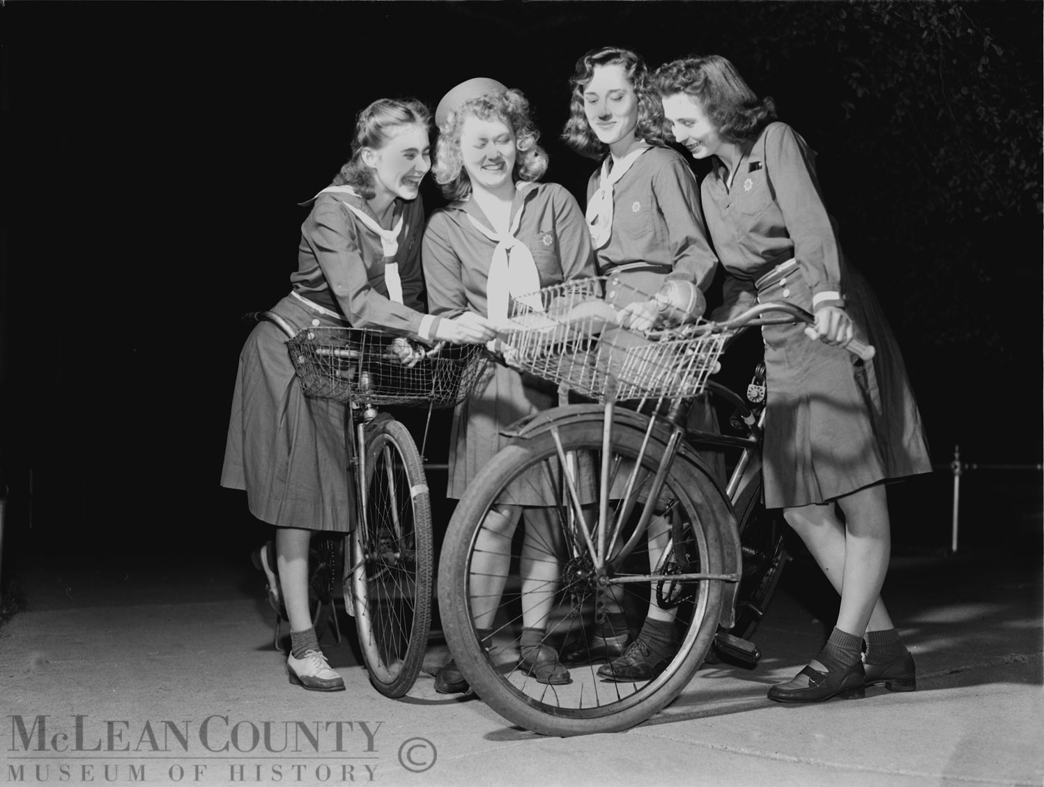 Seen here are Bloomington area Girl Scouts training as blackout and air raid messengers. From left to right: Charlotte Ratcliffe, Isabel Gottschalk, Kay Johnston, and Gloria Sampson.