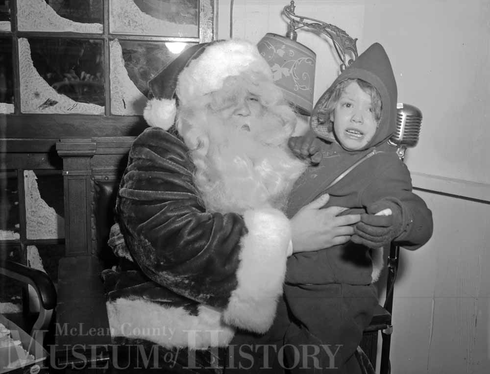 Crying child sits on Santa's lap, 1948